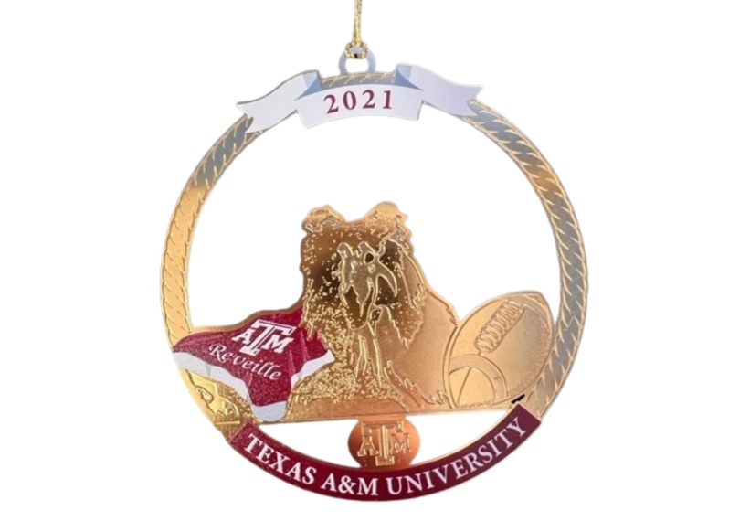 Product Description: This year’s Christmas in Aggieland ornament honors Reveille, the First Lady of Aggieland and Texas A&M’s official mascot.</br></br>Designed by local, Bryan-based artist Dr. Dary Dega, owner of Degallery Art Studio and Gallery (https://degallery.us), our 2021 Reveille ornament is both a tribute to Reveille IX, and a warm welcome to Reveille X.</br></br>Miss Rev, as she is affectionately known on campus, is the highest-ranking member in the Corps of Cadets and wears five silver diamonds (the Corps Commander only has four). That means if Miss Rev falls asleep in a cadet’s bed, the cadet must find somewhere else to sleep since she outranks him. Tradition also dictates that if Reveille is in class and barks, the professor should end class because Miss Rev is bored.</br></br>Enjoy this year’s Christmas in Aggieland ornament, “Reveille”, Merry Christmas and Gig ‘em!</br> 2021 Reveille